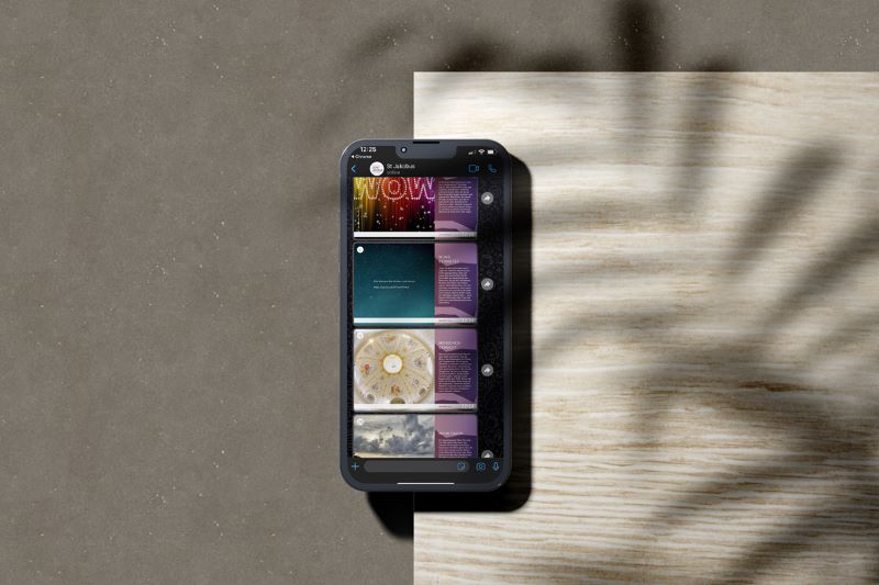 Ein Smartphone auf einem Holzbrett zeigt einen Chatverlauf mit Bildern im Jakobus-Design